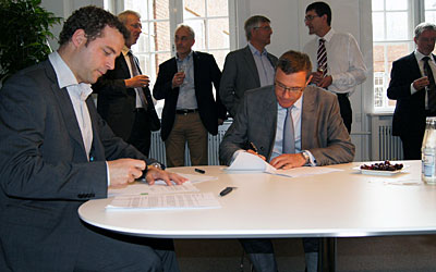 Uddannelsesminister Morten Østergaard og DTUs bestyrelsesformand Sten Schaibye underskriver udviklingskontrakter. I baggrunden ses de øvrige bestyrelsesformænd for universiteterne.